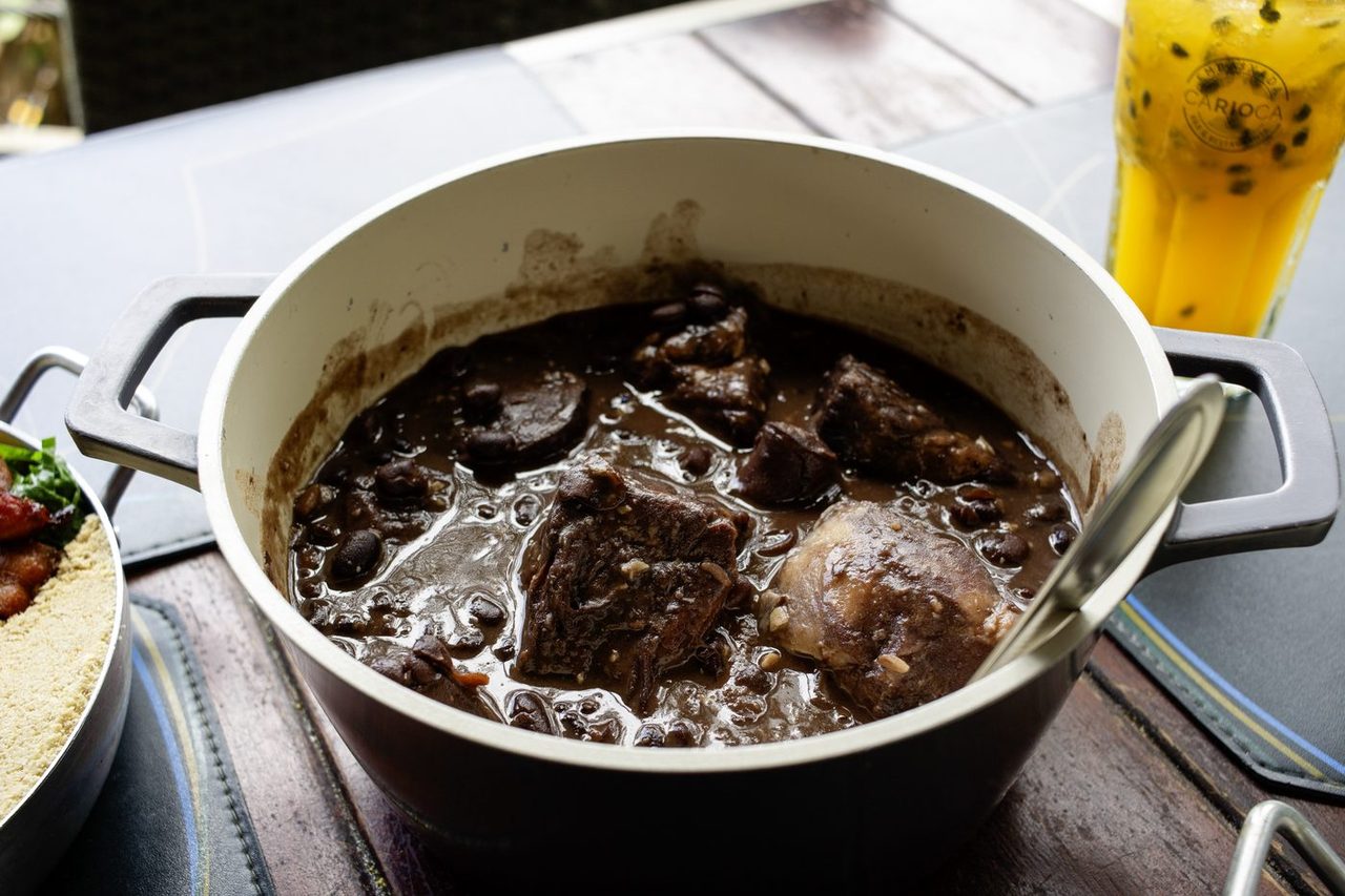 Feijoada servida no caldeirão com acompanhamentos