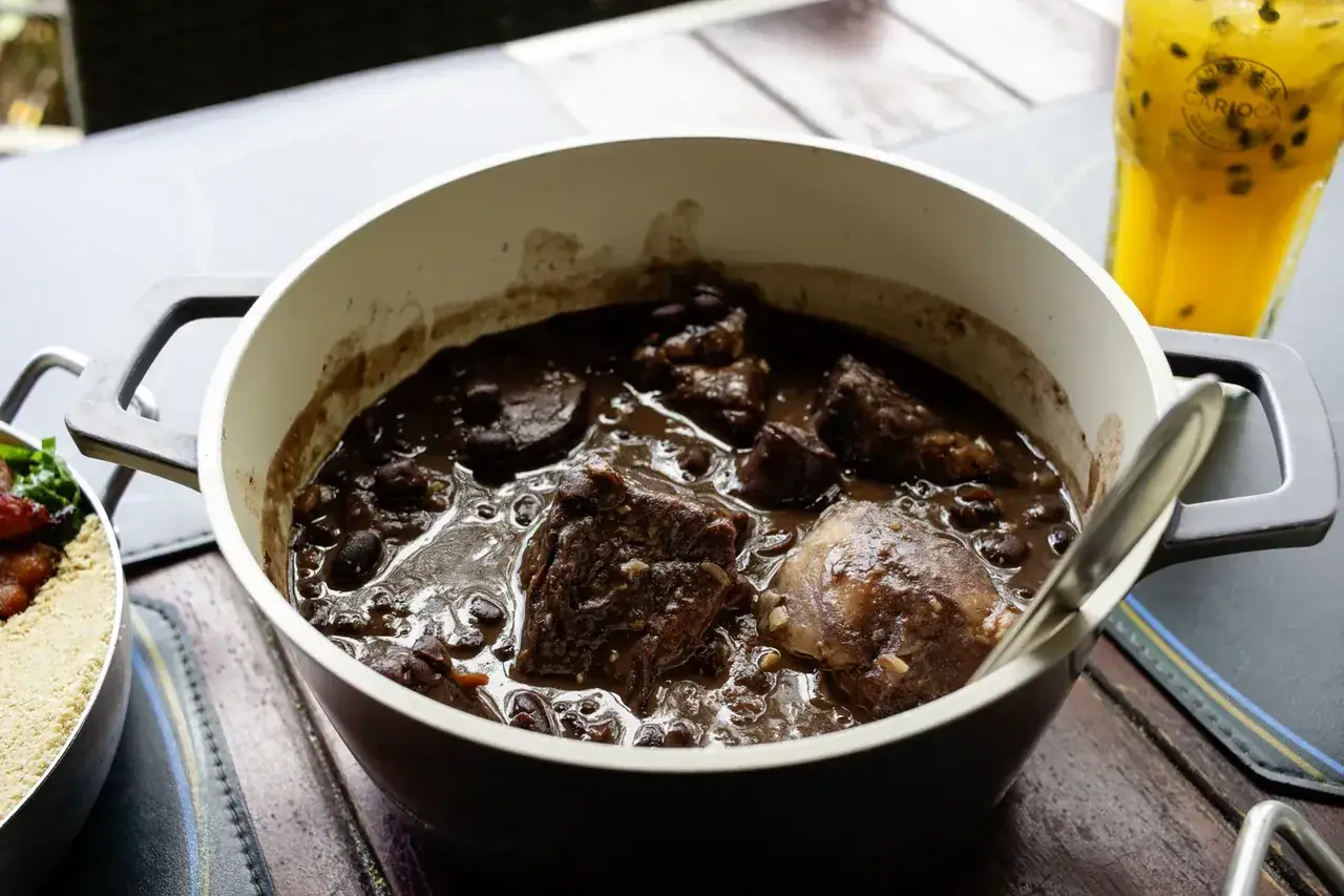 Feijoada completa no caldeirão, servida com acompanhamentos tradicionais