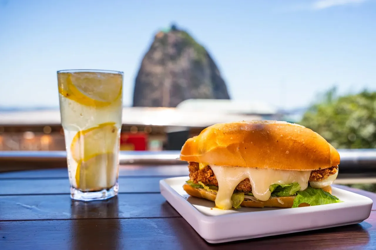 Sanduíche artesanal com o Pão de Açúcar ao fundo na Embaixada Carioca — café da manhã e brunch com vista no Morro da Urca, Rio de Janeiro